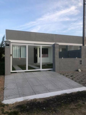 Casa em Atlântida Sul, com 2 quartos e 2 banheiros, com ar condicionado.